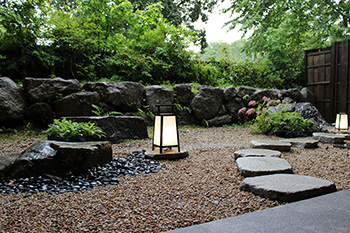 落ち着いた石組・植栽に照明が印象的な中庭